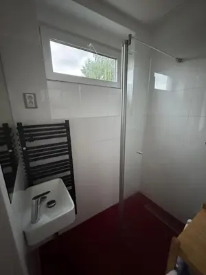 a bathroom with a sink and a shower with a window at Prague Cozy Hideaway in Lysolaje