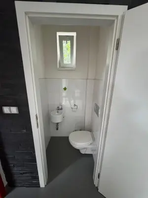 a small bathroom with a toilet and a sink at Prague Cozy Hideaway in Lysolaje