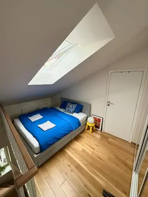 a bedroom with a bed and a skylight at Modern two-storey apartment with terrace in Prague