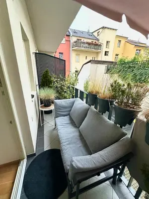 a couch sitting on a balcony with potted plants at Modern two-storey apartment with terrace in Prague