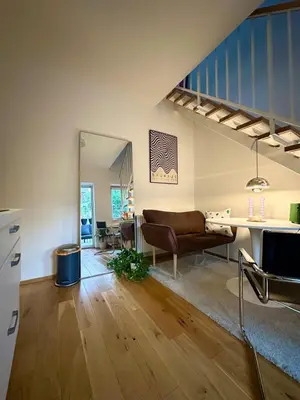 a living room with a couch and a staircase at Modern two-storey apartment with terrace in Prague
