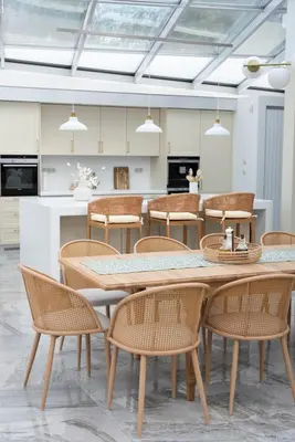 a dining room with a table and rattan chairs at Residence Sodomov
