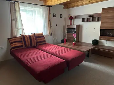 a red couch in a living room with a window at Ubytování uprostřed Evropy in Kouřim