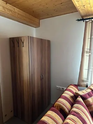 a bedroom with a wooden cabinet and a bed at Ubytování uprostřed Evropy in Kouřim