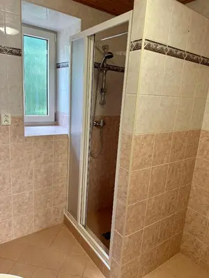 a shower with a glass door in a bathroom at Ubytování uprostřed Evropy in Kouřim