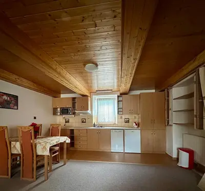 a kitchen with wooden ceilings and a table and chairs at Ubytování uprostřed Evropy in Kouřim