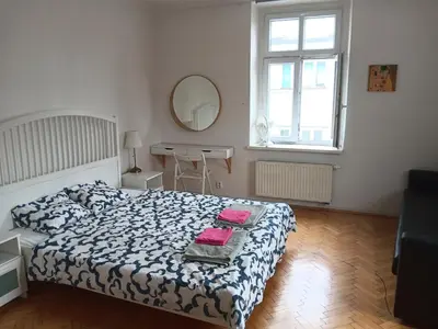 a bedroom with a bed and a table and a mirror at Cosy appartment close to main train station and city center in Prague