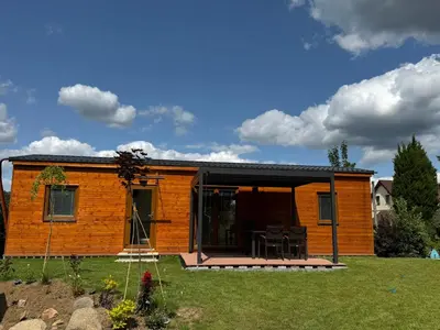 a log cabin with a porch and a patio at Domky Slapy pod golfem in Slapy