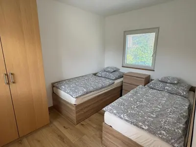 a living room with a blue couch and a kitchen at Domky Slapy pod golfem in Slapy