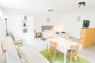 a living room with a table and a bed at Ubytování na faře in Prague