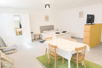 a living room with a table and a kitchen at Ubytování na faře in Prague