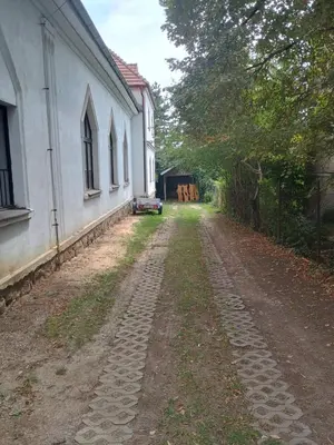 an empty dirt road next to a white building at Ubytování na faře in Prague