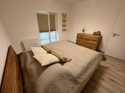 a bedroom with a bed and a dresser and a window at Prague Airport Family Lodging in Tuchoměřice