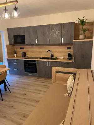 a kitchen with a bench in the middle of it at Prague Airport Family Lodging in Tuchoměřice