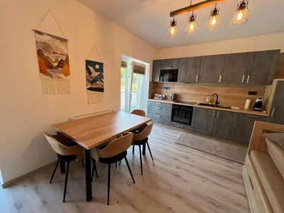 a kitchen with a wooden table and chairs at Prague Airport Family Lodging in Tuchoměřice