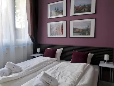 a bedroom with two white beds and pictures on the wall at PRAGUE's Hidden Pearl - center in Prague