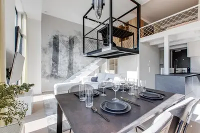 a dining room with a table with plates and wine glasses at Designer Loft Apartment Holešovice, Parking, Balcony in Prague