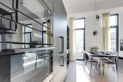 a kitchen and dining room with a table and chairs at Designer Loft Apartment Holešovice, Parking, Balcony in Prague