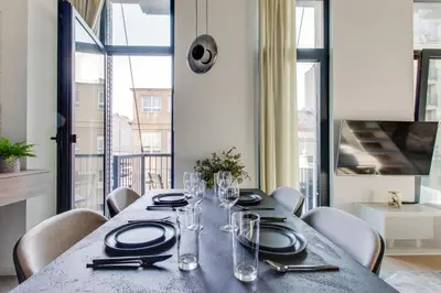 a dining room with a table with plates and glasses at Designer Loft Apartment Holešovice, Parking, Balcony in Prague