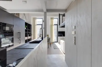 a kitchen with white cabinets and a counter top at Designer Loft Apartment Holešovice, Parking, Balcony in Prague