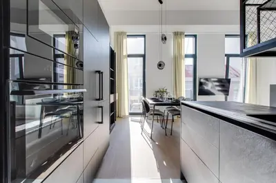 a kitchen with a counter and a dining room at Designer Loft Apartment Holešovice, Parking, Balcony in Prague