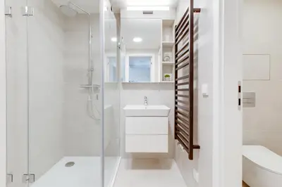a white bathroom with a shower and a sink at Designer Loft Apartment Holešovice, Parking, Balcony in Prague