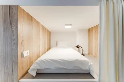 a bedroom with a bed with white sheets at Designer Loft Apartment Holešovice, Parking, Balcony in Prague