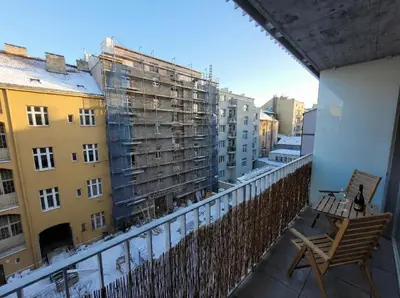 a balcony with a chair and some buildings at Karlin Executive - Standing Desk, Monitor & Garage in Prague
