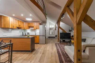 a kitchen and living room with a couch and a table at Parkview Penthouse in Prague
