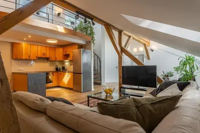 a living room with a couch and a kitchen at Parkview Penthouse in Prague