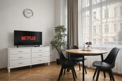 a dining room with a table and a clock on the wall at Cozy Prague Apartment in Prague