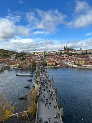 a group of people walking on a bridge over a river at Cozy Prague Apartment in Prague