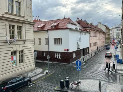 a city street with buildings and a horse drawn carriage at Cozy Prague Apartment in Prague