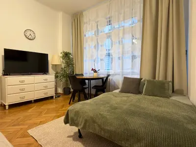 a bedroom with a bed and a table and a television at Cozy Prague Apartment in Prague