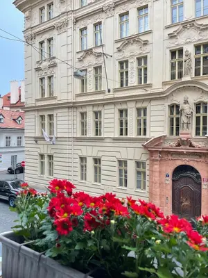 a large building with red flowers in front of it at Cozy Prague Apartment in Prague
