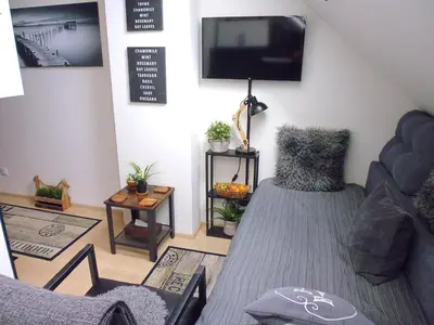a living room with a couch and a tv at Cozy Studio on Metro in Prague
