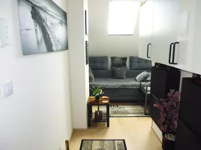 a kitchen with a couch and a chair in a room at Cozy Studio on Metro in Prague