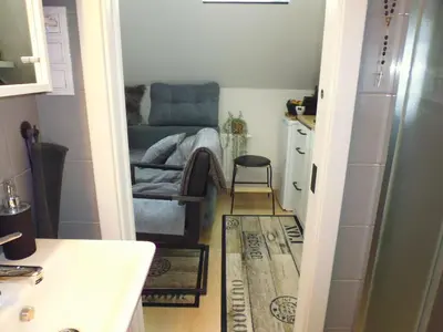 a hallway with a chair and a picture on the wall at Cozy Studio on Metro in Prague