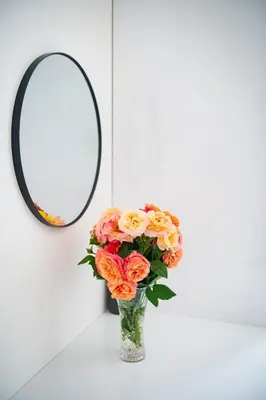 a vase of flowers in front of a mirror at Apartment Spalená in Prague