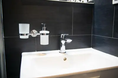 a white sink in a bathroom with black walls at Apartment Spalená in Prague