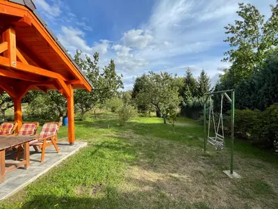 a wooden pavilion with chairs and a swing at Domek Nad Drahou Mělník in Pšovka