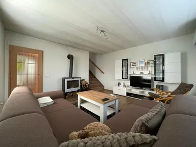 a living room with a couch and a tv at Domek Nad Drahou Mělník in Pšovka