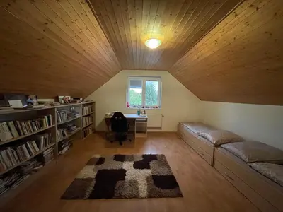 a room with a couch and a desk in a attic at Domek Nad Drahou Mělník in Pšovka
