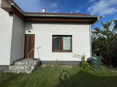 a white house with a door and a window at Domek Nad Drahou Mělník in Pšovka