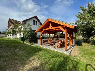a gazebo with a table and chairs in a yard at Domek Nad Drahou Mělník in Pšovka