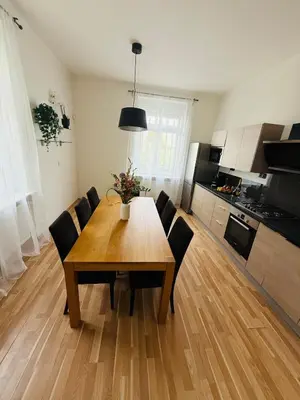 a dining room table with chairs and a kitchen at Family Villa Hanspaulka in Prague
