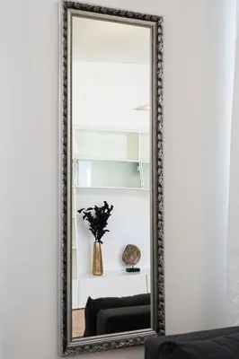 a mirror hanging on a white wall in a living room at Golden Cat Suite in Prague