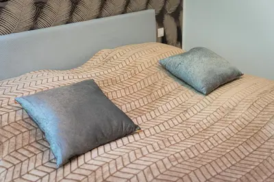 a bed with two pillows on top of it at Golden Cat Suite in Prague