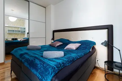 a bedroom with a large bed with blue sheets and pillows at Golden Cat Suite in Prague
