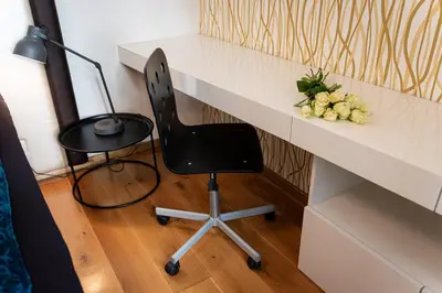 a desk with a chair and flowers on it at Golden Cat Suite in Prague